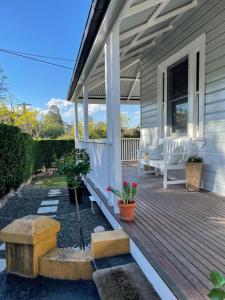 a house with a wooden deck with a bench on it at ‘Tara-Lee’ in Cessnock