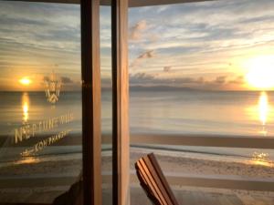 a window with a view of the ocean and the sunset at Neptune's Villa in Haad Rin