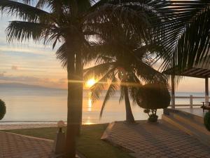 a view of the sunset from a resort with palm trees at Neptune's Villa in Haad Rin