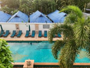 a pool at a resort with blue chairs and palm trees at Neptune's Villa in Haad Rin