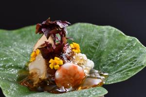 a beetle on a green leaf with flowers on it at Kyo Yunohana Resort Suisen in Kameoka