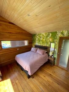 a bedroom with a bed in a wooden house at Pucontours River Lodge in Pucón