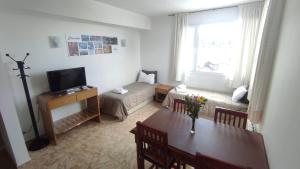 un soggiorno con tavolo, divano e TV di Apartamentos Rolando a San Carlos de Bariloche
