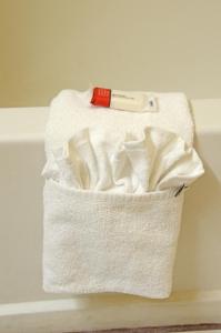 una pila de toallas blancas con un cuchillo encima en Super 8 by Wyndham Warrenton, en Warrenton