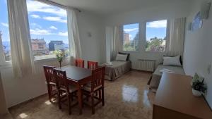 a living room with a table and chairs and a couch at Apartamentos Rolando in San Carlos de Bariloche