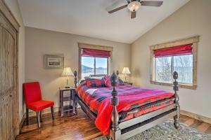 1 dormitorio con 1 cama y 1 silla roja en Cripple Creek Retreat with Incredible Mtn Views!, en Cripple Creek