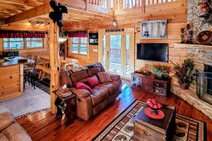 a living room with a couch and a television in a cabin at On Solid Ground in Sevierville