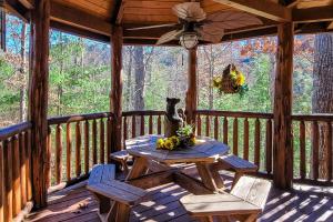 a wooden porch with a picnic table and chairs on it at On Solid Ground in Sevierville