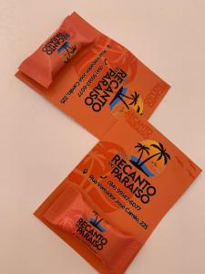two orange bags of assam snacks sitting on a table at Chalé Recanto do Paraíso in Galinhos