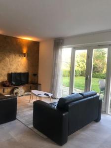 a living room with a couch and a table at Strand Villa Stern Noordwijk in Noordwijk