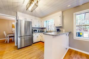 a kitchen with white cabinets and a stainless steel refrigerator at On The Berg in Helen