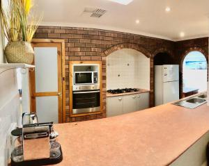 a kitchen with a counter and a stove top oven at Beach front 4 x2 Home with pool in Geraldton