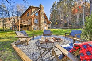 a backyard with a table and chairs and a log cabin at Creekside Bryson City Cabin with Private Hot Tub in Bryson City