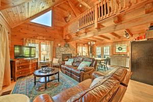 a living room with a couch and a tv at Creekside Bryson City Cabin with Private Hot Tub in Bryson City