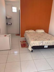 1 dormitorio con 1 cama y suelo de baldosa blanca en Chalé Recanto do Paraíso en Galinhos