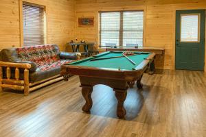 a living room with a pool table and a couch at The Lazy Bear in Pigeon Forge