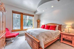 a bedroom with a large bed and a red chair at Red Snowshoes & Stay in Solitude in Solitude