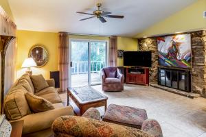 a living room with a couch and a tv at The Guest House at Big Bear Estates in Waynesville