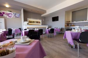 un ristorante con tavoli e sedie viola con tovaglia viola di Hotel l'Approdo a Porto Azzurro