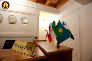 Un escritorio con un cartel con banderas. en Shohnishin Boutique, en Bukhara