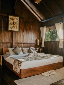 Da'Kayu Bali Homestay في موندوك: غرفة نوم بسرير كبير في غرفة