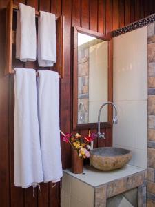 uma casa de banho com toalhas brancas e um lavatório em Da'Kayu Bali Homestay em Munduk