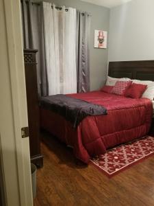 a bedroom with a bed with a red comforter at Beautiful City Lights and Mountain Views in Menifee
