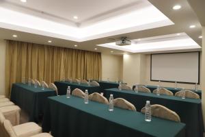 a conference room with blue tables and chairs and a white screen at Guangdong Victory Hotel in Guangzhou