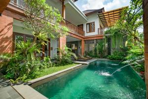 a swimming pool in the backyard of a house at Uma Shanti Villa by Mahaputra in Ubud