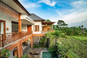 a house with a deck and a swimming pool at Uma Shanti Villa by Mahaputra in Ubud