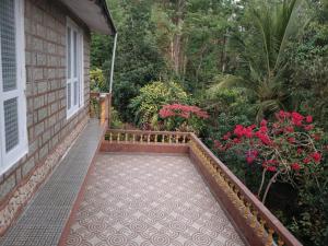 a porch of a house with a flower garden at Hill side estate in Madikeri