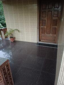 a front door of a house with a tile floor at Hill side estate in Madikeri