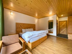 a bedroom with a large bed and a wooden ceiling at Hotel Batseri SANGLA in Sāngla