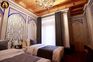 Un dormitorio con dos camas y una lámpara de araña. en Shohnishin Boutique, en Bukhara 76 fotos más