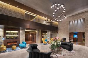 a lobby with a fireplace and chairs and a chandelier at Hyatt Centric Levent Istanbul in Istanbul