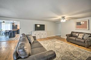 a living room with a couch and a flat screen tv at 11 Mi to Lake Ouachita Family Cabin with Yard in Royal