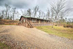 a house on the side of a dirt road at 11 Mi to Lake Ouachita Family Cabin with Yard in Royal