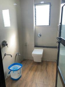 a bathroom with a toilet and a window and a bucket at Hotel Padmawati Grand in Nānded +18 photos