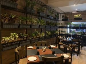 a restaurant with tables and chairs and potted plants at Hotel Padmawati Grand in Nānded