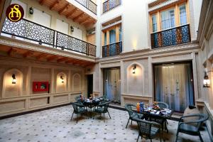 una habitación con mesas y sillas en un edificio en Shohnishin Boutique, en Bukhara