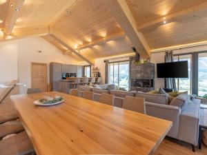 a dining room and living room with a wooden table at Luxury chalet with pool and sauna, skilift at 500m in Ennsling