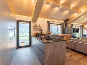 a kitchen with a counter and a living room at Luxury chalet with pool and sauna, skilift at 500m in Ennsling