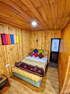 a bedroom with a bed in a wooden room at Pigeons Nest in Nuwara Eliya