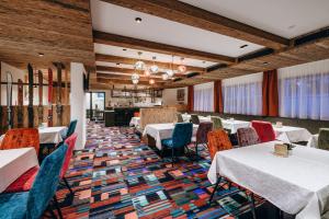a dining room with tables and chairs and wooden ceilings at Hotel Grieserin in Sankt Anton am Arlberg