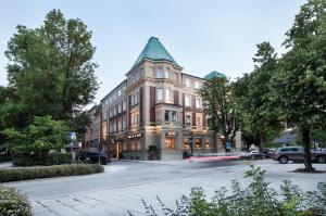 ein großes Gebäude mit einem grünen Dach auf einer Straße in der Unterkunft Parkhotel Traunstein in Traunstein