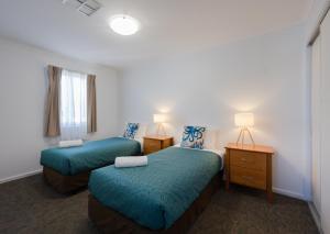 a hotel room with two beds and two lamps at Comfort Inn Warrnambool International in Warrnambool