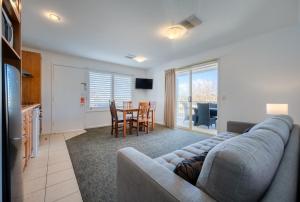 a living room with a couch and a table with chairs at Comfort Inn Warrnambool International in Warrnambool