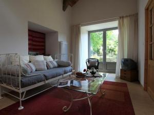 a living room with a couch and a glass table at Gîte familial restauré avec jardin clos, équipements bébé, animaux acceptés, proche St-Julien-Chapteuil - FR-1-582-296 in Saint-Julien-Chapteuil