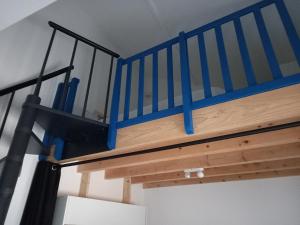 una scala in legno con ringhiera blu in una stanza di Relais de la truffière a Villaines-en-Duesmois
