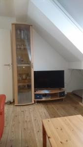 a living room with a flat screen tv in an attic at Ferienwohnung Spatzennest in Fladungen